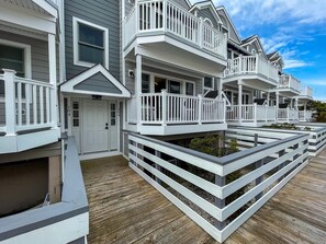 Une rangée de maisons côtières avec des balustrades blanches et une terrasse en bois.