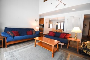 A living room with two sofas, a coffee table, and a lamp.