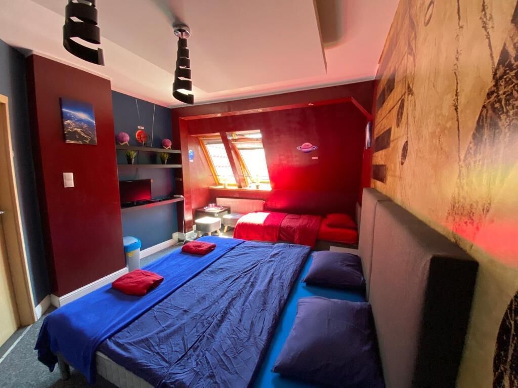 Ein Zimmer mit einem Bett, einem Schreibtisch und einem Fenster.