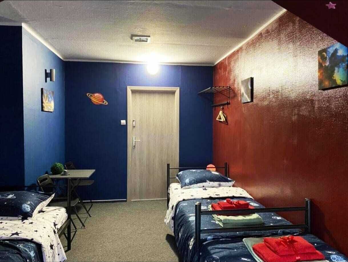 Una habitación con dos camas, un escritorio y una puerta.