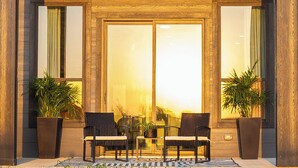 A modern building entrance with two chairs and a table, flanked by large windows and potted plants. - Lake on Winnetka Dream Home - Trinity Grove & Downtown Dallas (Dallas)