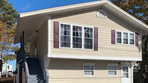 Une maison à deux étages avec un porche à l’avant, un escalier et un garage.