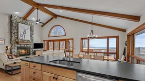 A spacious kitchen with wooden cabinets, a stainless steel dishwasher, and large windows offering views of the outdoors. - Daisy Ridge - Expansive Mountain View, Pets OK, Beech Mtn Club option, foosball, arcade (Beech Mountain)