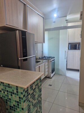 Private kitchen - New apartment with large balcony and swimming pools. (Guarujá)