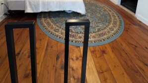 A bedroom with a bed, a TV, a dresser, and a patterned rug.