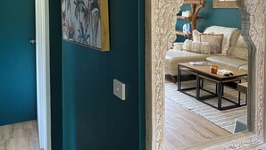 A hallway with teal walls, a large ornate mirror, and a framed botanical print. - OP 63 - Rest & Recharge at Your Beachside Escape (Coffs Harbour)