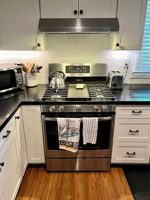 A kitchen with a stainless steel stove, microwave, and toaster. - Comfy guest house with AC in sunny North Hollywood! (Los Angeles)