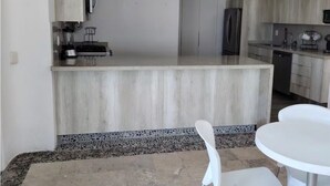 A kitchen with a central island, white chairs, and a dining table. - Comfortable House with excellent view Acapulco (Acapulco de Juárez)