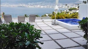 A rooftop terrace with a pool, chairs, and a view of the city and mountains. - Comfortable House with excellent view Acapulco (Acapulco de Juárez)