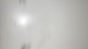 En enkel vägg med en enda lampa och ett synligt eluttag.