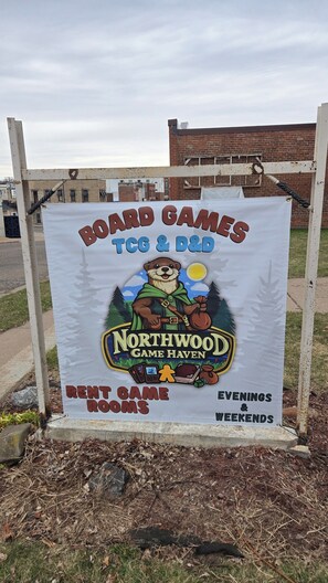 A sign for Northwood Game Haven advertising board games, TCG & D&D, and offering rent game rooms.