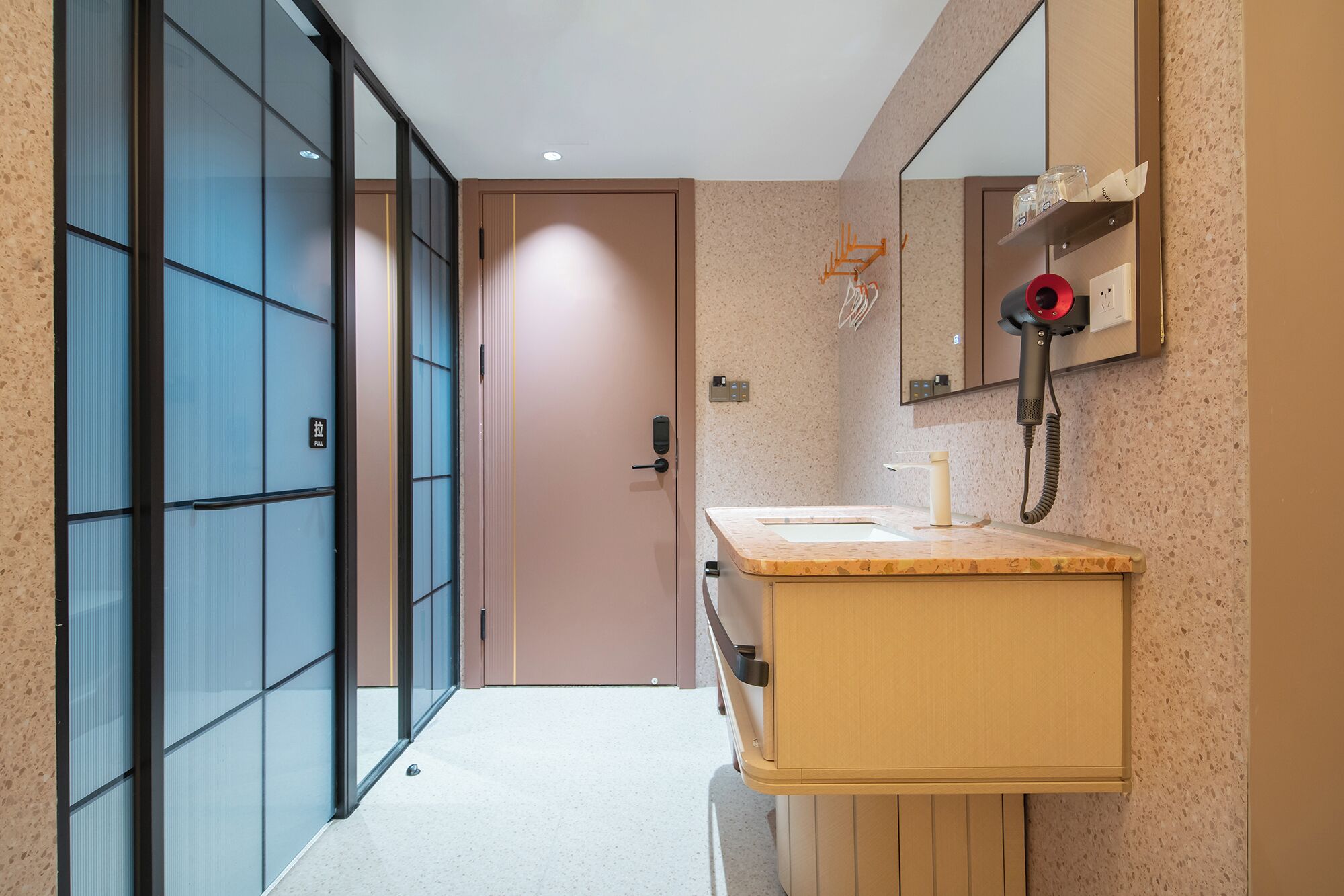 A modern bathroom with a sink, mirror, and hairdryer.