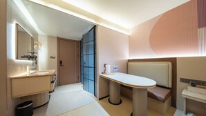 Un baño moderno con tocador, espejo y zona de estar.