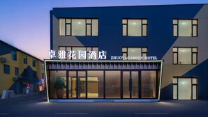Un hotel con fachada moderna, ventanas grandes y un letrero que indica que es el Zhuoyagarden Hotel.