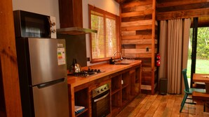 Une cuisine compacte équipée d’un réfrigérateur, d’un four à micro-ondes, d’une cuisinière et d’un four.