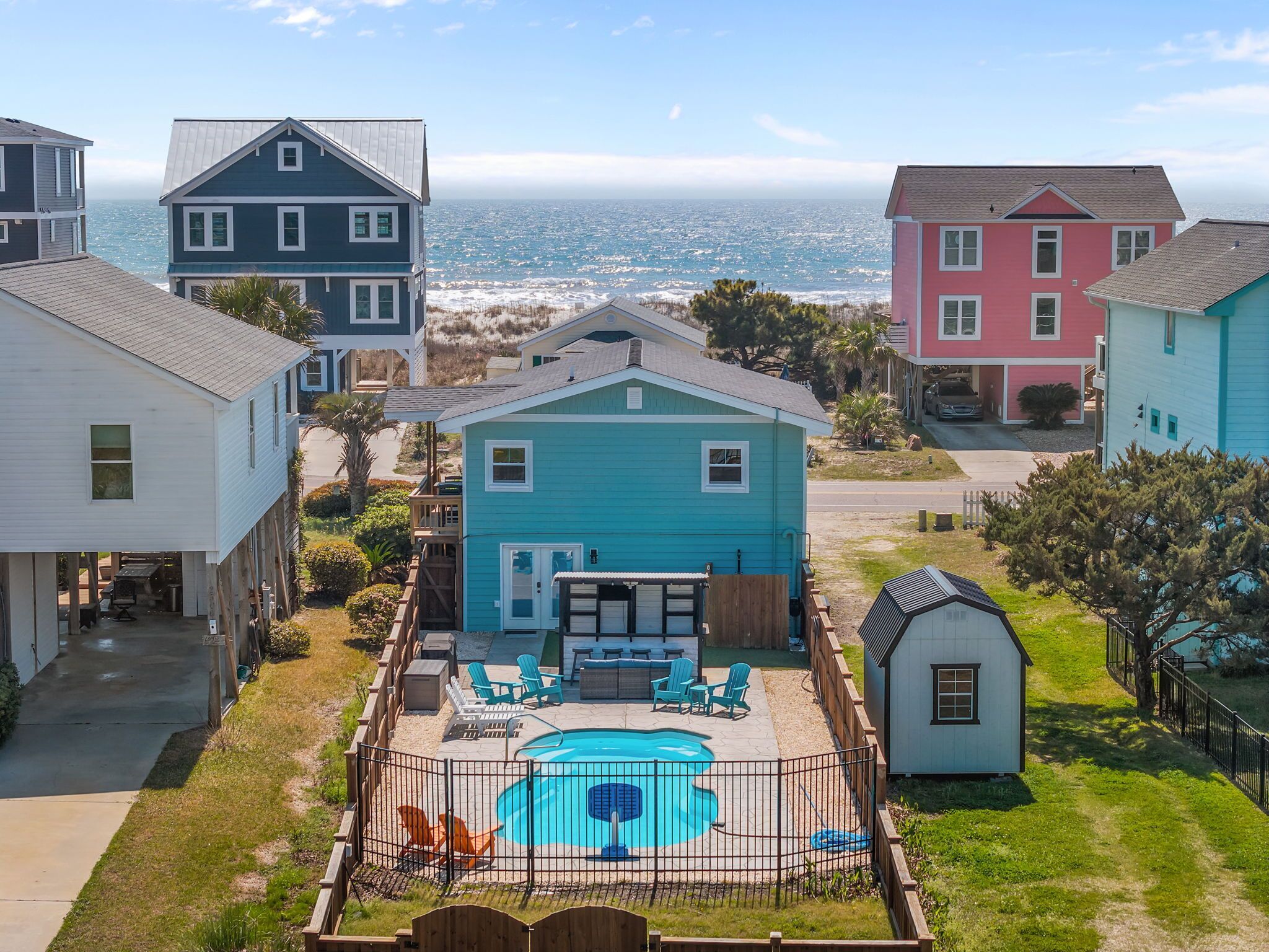 Un quartier résidentiel avec des maisons, une piscine et une vue sur l’océan.
