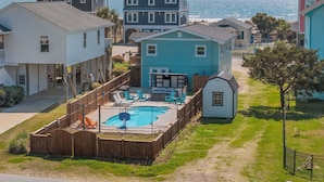A residential area with houses, a swimming pool, and a view of the ocean.