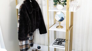 A vanity with a mirror, a book, and a glass of wine.