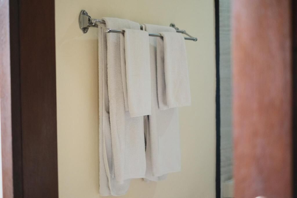 A bathroom with a towel rack holding two towels.