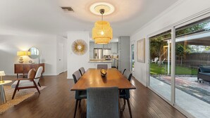Un coin repas avec une table en bois, des chaises et un luminaire suspendu.
