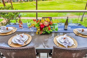 A table set for four with a view of a well-maintained lawn. - Honua Kai | Ocean View 5 BR, Sleeps 16 | Car Incl. w/ 6+ Nights | HKH ML-2654 by KBM (Lahaina)