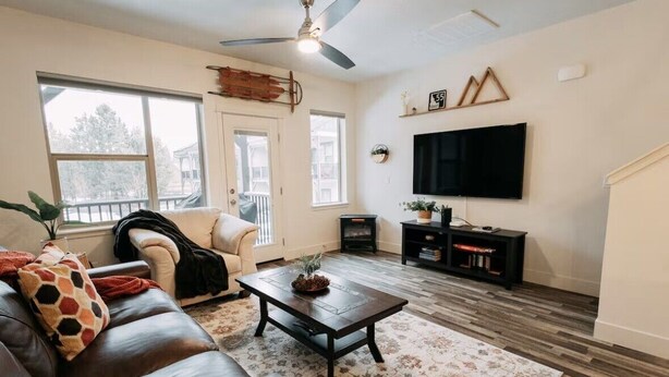 Ein Wohnzimmer mit einer Couch, einem Couchtisch, einem Fernseher und einem Kamin.