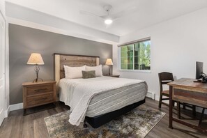 A bedroom with a bed, bedside tables, a desk, and a chair. - Quail Run 3315 - Renovated, Hot Tub, Garage, W/D + EZCancel (Steamboat Springs)
