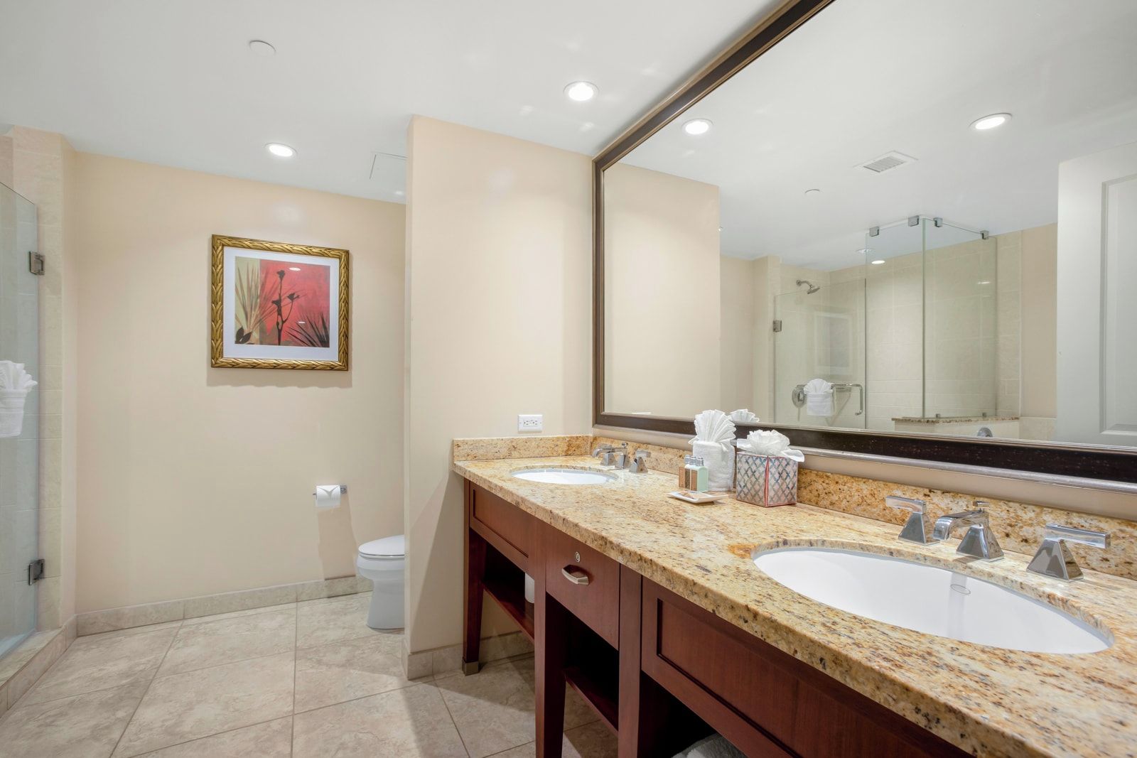 A bathroom with two sinks, a large mirror, and a framed picture on the wall.