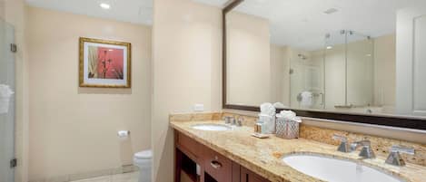 A bathroom with two sinks, a large mirror, and a framed picture on the wall.