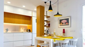 Een moderne keuken met witte kasten, houten details en hanglampen.