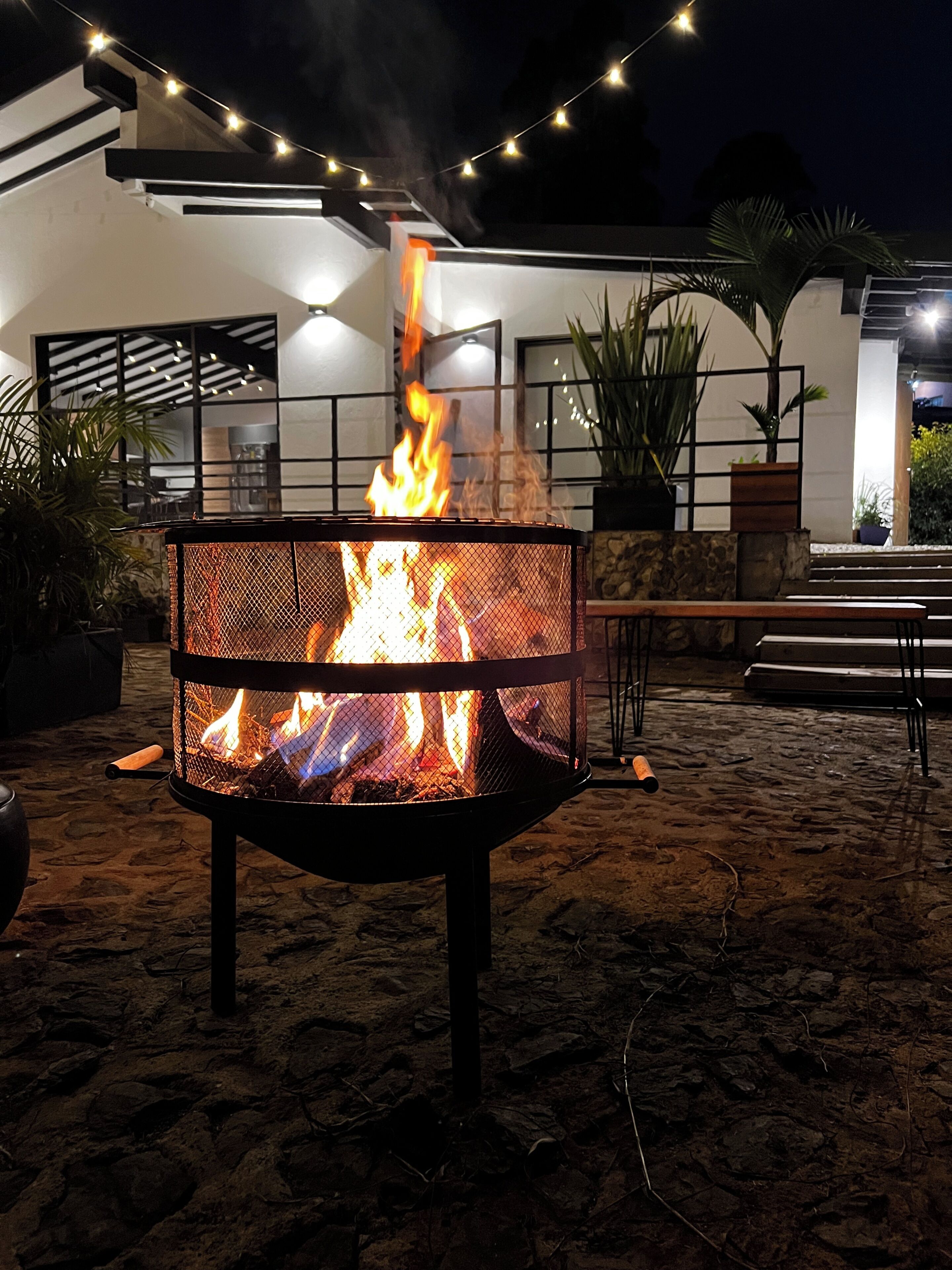 Un pozo de fuego en un patio con un edificio moderno al fondo.