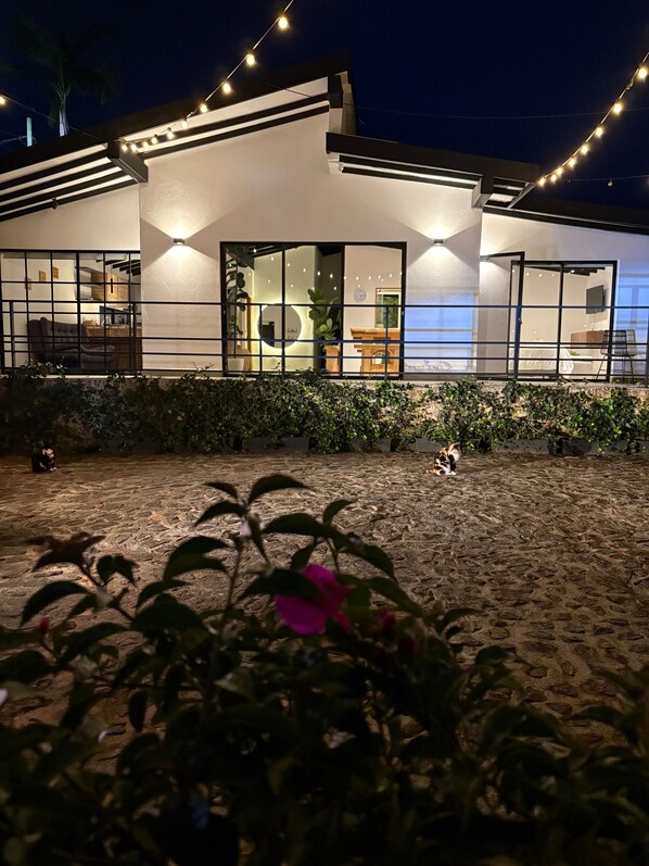 A modern building with a covered outdoor area, a visible staircase, and a seating area. - Casa de campo cerca al aeropuerto MDE (Rionegro)