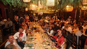 A crowded indoor dining area with tables set for meals, surrounded by hanging plants and warm lighting. - Casa de campo cerca al aeropuerto MDE (Rionegro)