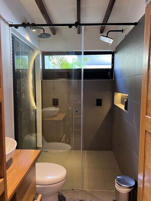 A modern bathroom with a glass shower enclosure, a toilet, and a sink. - Casa de campo cerca al aeropuerto MDE (Rionegro)