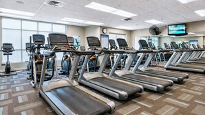 Una palestra con tapis roulant, cyclette e macchine ellittiche.