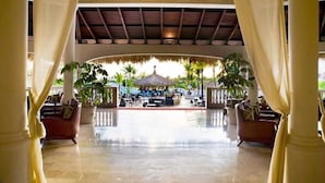 Et hotel lobby med en pool, potteplanter og en bindingsværksbygning.