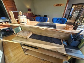 Balcão de madeira com teclado de computador, moedor de café e bandeja de copos.