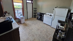 A compact kitchen with a stove, refrigerator, and a coffee maker.