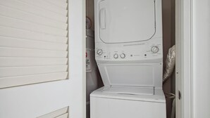 A compact, white laundry room with a built-in washer and dryer, a control panel with various settings, and a vent hose. - Honua Kai | Ocean View 4 BR, Sleeps 14 | Car Incl. w/ 6+ Nights | HKH ML-2801 by KBM (Lahaina)