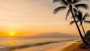 A beach with palm trees and a sunset. - Honua Kai | Ocean View 4 BR, Sleeps 14 | Car Incl. w/ 6+ Nights | HKH ML-2801 by KBM (Lahaina)