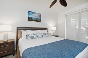 A hotel room with a bed, two bedside tables with lamps, a large window, and a framed picture on the wall. - Honua Kai | Ocean View 6 BR, Sleeps 20 | Car Incl. w/ 6+ Nights | HKH ML-2804 by KBM (Lahaina)