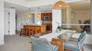 A modern kitchen with wooden cabinets, a central island, and pendant lighting. - Honua Kai | Ocean View 6 BR, Sleeps 20 | Car Incl. w/ 6+ Nights | HKH ML-2807 by KBM (Lahaina)