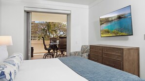 A bedroom with a bed, a dresser, a TV, and a balcony with a table and chairs. - Honua Kai | Ocean View 6 BR, Sleeps 20 | Car Incl. w/ 6+ Nights | HKH ML-2807 by KBM (Lahaina)
