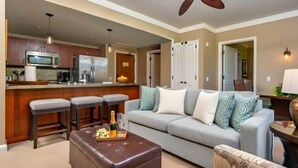 A modern kitchen with a microwave, refrigerator, and bar stools. - Honua Kai | Ocean View 6 BR, Sleeps 20 | Car Incl. w/ 6+ Nights | HKH ML-2807 by KBM (Lahaina)