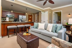 A modern kitchen with a microwave, refrigerator, and bar stools. - Honua Kai | Ocean View 6 BR, Sleeps 20 | Car Incl. w/ 6+ Nights | HKH ML-2807 by KBM (Lahaina)