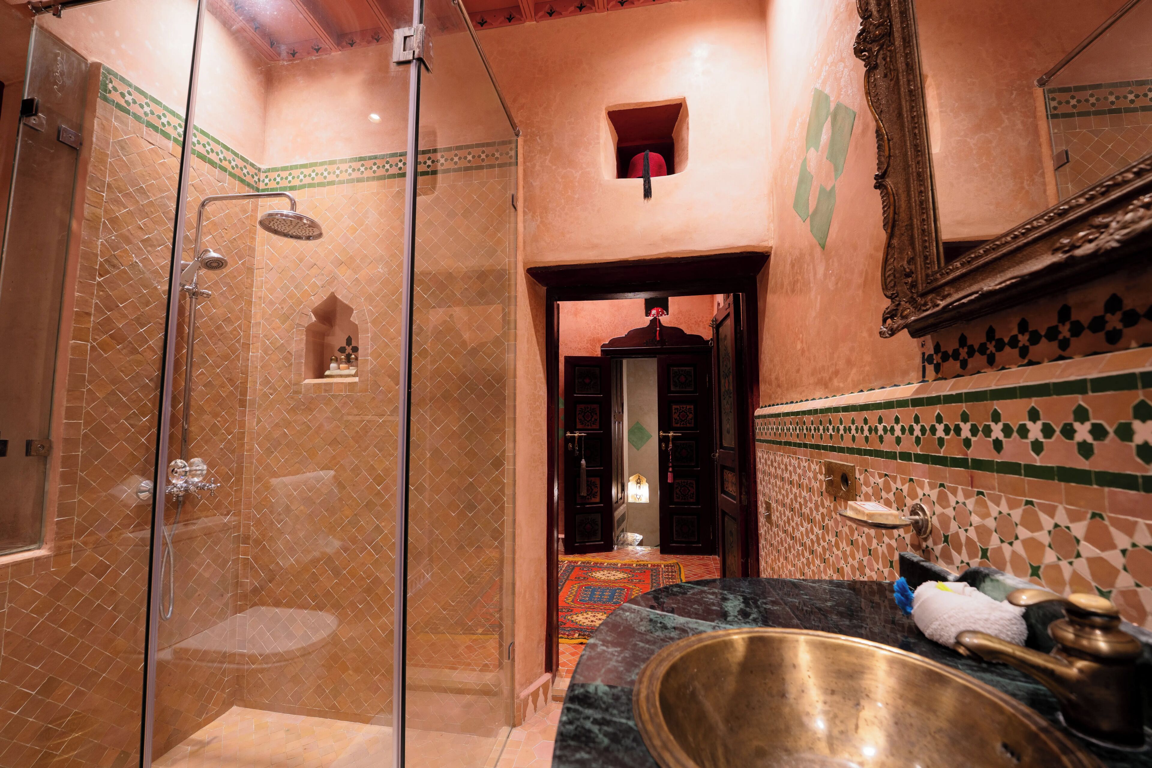 Un baño con ducha, un lavabo de peltre y un espejo.