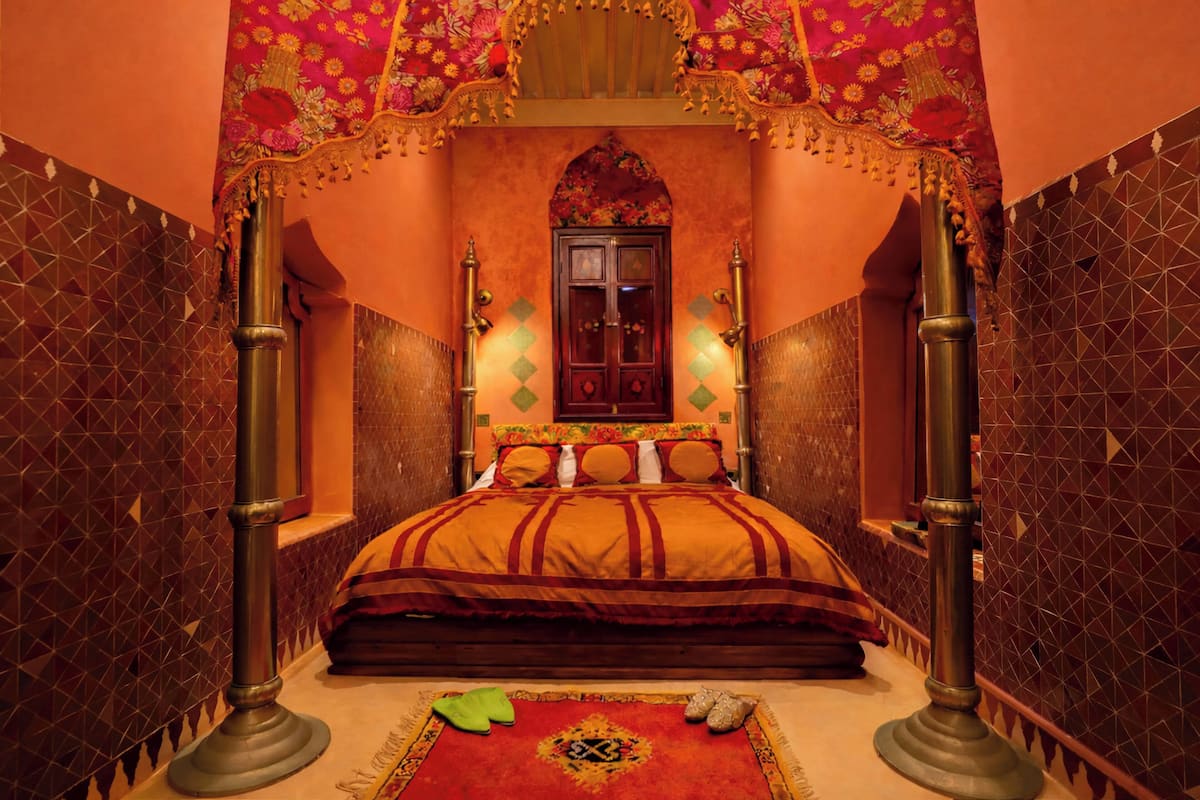 A room with a bed, a window, and a decorative archway.