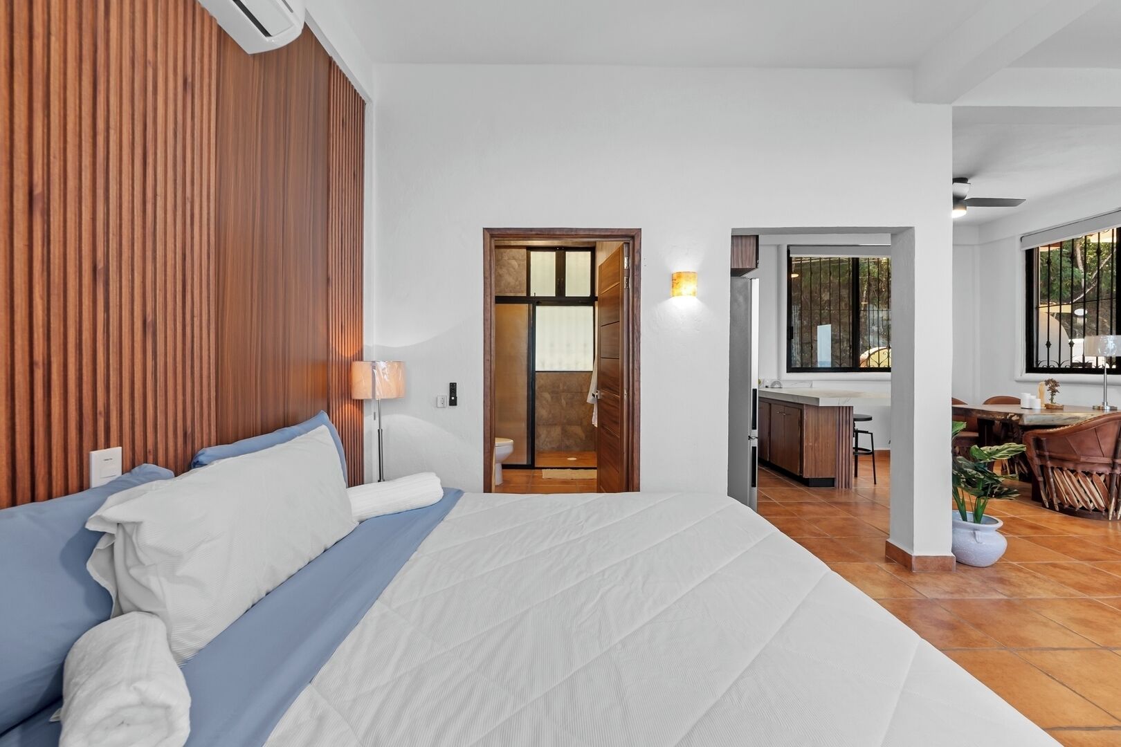 A hotel room with a bed, a desk, a chair, and a window.