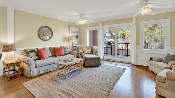 A living room with a sofa, armchair, coffee table, and a rug. - Charming Tybee Island Escape on the South End | Heated Pool Access (Tybee Island)