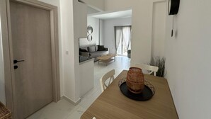 Ein modernes Wohnzimmer mit einer Couch, einem Couchtisch und einem Esstisch mit Stühlen.